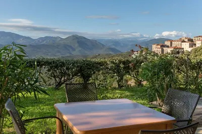 a table and chairs with a view of the mountains at Best Western Plus San Damianu in Sartène