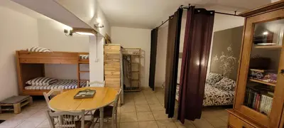 a room with a table and a bedroom with bunk beds at Gites San Austinu in Petreto-Bicchisano