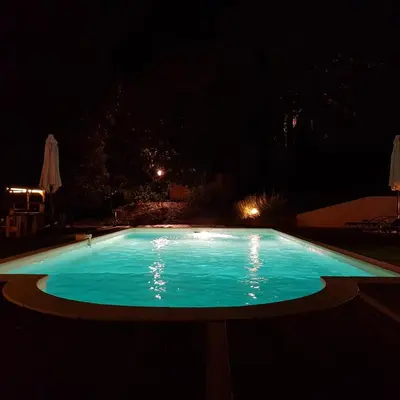 a swimming pool lit up at night at Gites San Austinu in Petreto-Bicchisano