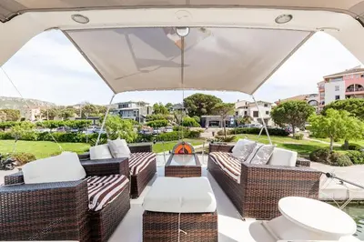 a patio with wicker furniture and an umbrella at Ocean Yacht Trawler - Le Caloa in Porto-Vecchio