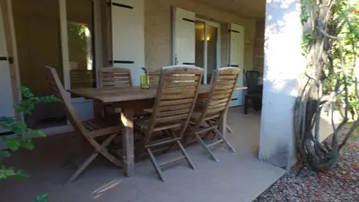 a wooden table and chairs on a patio at residence stella d'oro in Porto-Vecchio
