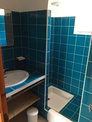 a blue tiled bathroom with a sink and a tub at residence stella d'oro in Porto-Vecchio