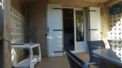 a porch with two blue chairs and a door at residence stella d'oro in Porto-Vecchio