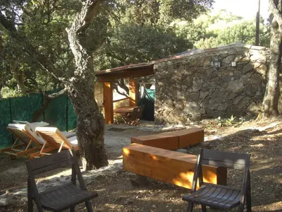two chairs and a bench in front of a cabin at Maisonnette du berger de Croccano in Sartène