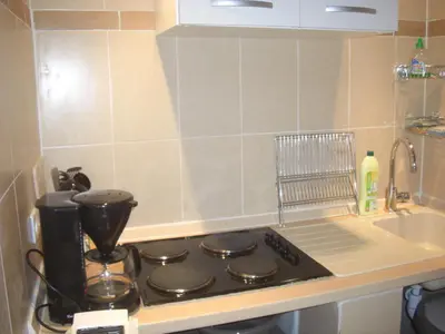a kitchen counter with a stove and a sink at Maisonnette du berger de Croccano in Sartène