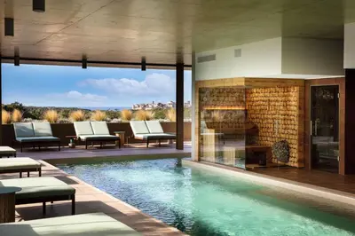 a swimming pool with a fireplace in a house at Hôtel & Spa Version Maquis Citadelle in Bonifacio
