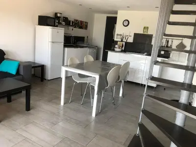 a kitchen and dining room with a table and chairs at Chez Muriel in Porto-Vecchio