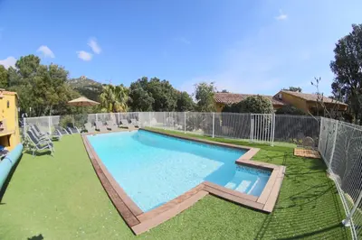 a swimming pool in a yard with a fence at Chez Muriel in Porto-Vecchio