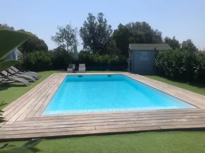 a large swimming pool with a wooden deck at Chez Muriel in Porto-Vecchio