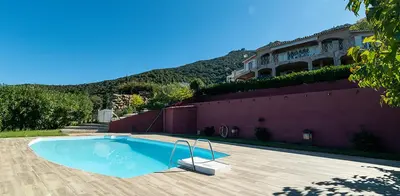 a swimming pool in front of a house at Au coeur de l'arriere Pays Rez de chaussé de Villa DOMAINE A PRESA in Sartène
