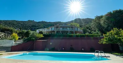 a swimming pool in front of a house at Au coeur de l'arriere Pays Rez de chaussé de Villa DOMAINE A PRESA in Sartène