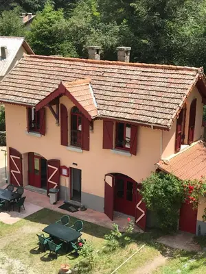 a small house with red doors and a patio at Le Vizzavona in Vizzavona