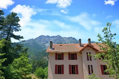 a house with a mountain in the background at Le Vizzavona in Vizzavona