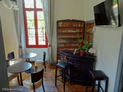 a living room with tables and chairs and a tv at Le Vizzavona in Vizzavona