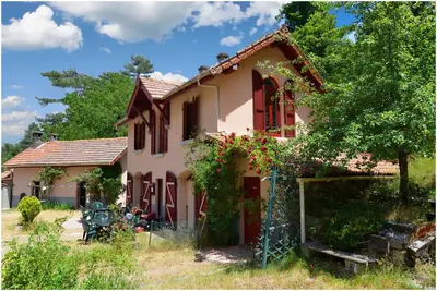 a house with red windows and a fence at Le Vizzavona in Vizzavona