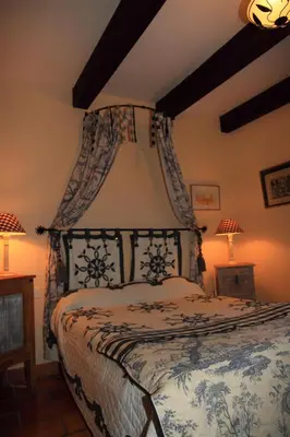 a bedroom with a bed with a blue and white bedspread at CASA-CORSA chambre d'hote in Cervione