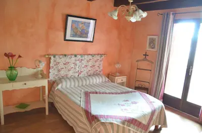 a bedroom with a bed and a desk and a window at CASA-CORSA chambre d'hote in Cervione