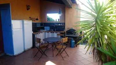a kitchen with a table and chairs and a refrigerator at CASA-CORSA chambre d'hote in Cervione