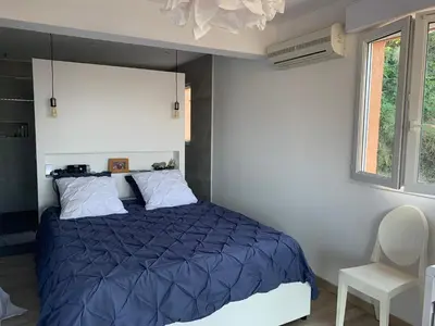 a bedroom with a blue bed and a chair at Chez Marc et Jeannick in Belvédère