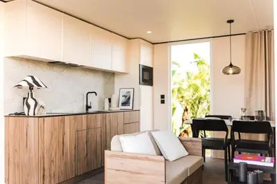 a living room with a couch and a kitchen at Camping Golfo Di Sogno in Porto-Vecchio