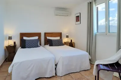 two beds in a room with a window at Résidence MARINA SERENA in Porto-Vecchio