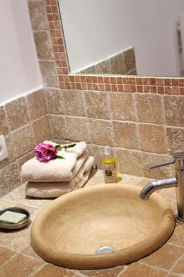 a bathroom sink with a flower on top of it at Résidence MARINA SERENA in Porto-Vecchio