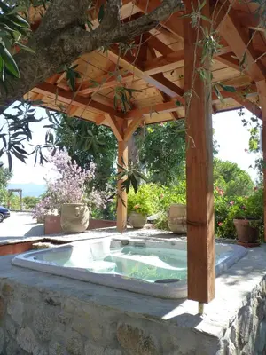 an outdoor hot tub under a wooden pergola at VbyOnyx in Olmeto