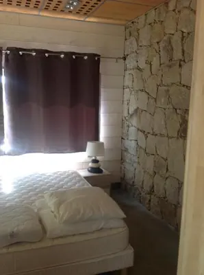 a bedroom with a bed and a stone wall at VbyOnyx in Olmeto