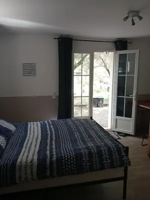 a bedroom with a bed and a sliding glass door at Berbi Rosse in Oletta