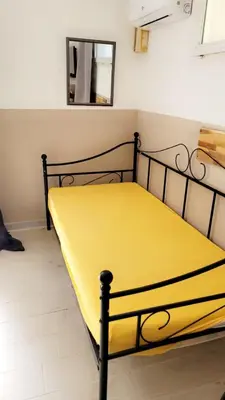a yellow bed in a room with a mirror at Berbi Rosse in Oletta