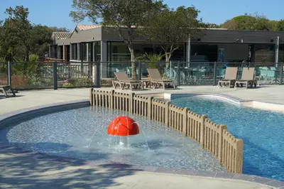a pool with a red ball in the water at Camping Le Damier in Pianottoli-Caldarello