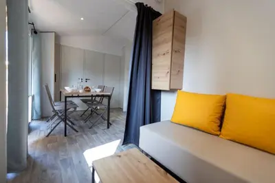 a room with a bed and a dining room with a table at Camping Le Damier in Pianottoli-Caldarello