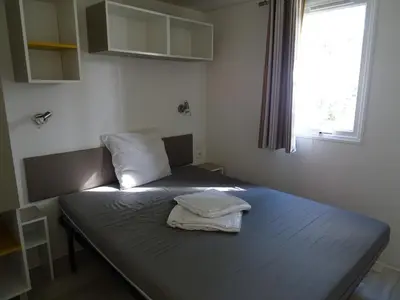 a bed in a small room with a window at Camping Via Romana in Prunelli-di-Fiumorbo