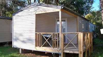 a small white shed with a large open door at Camping Via Romana in Prunelli-di-Fiumorbo