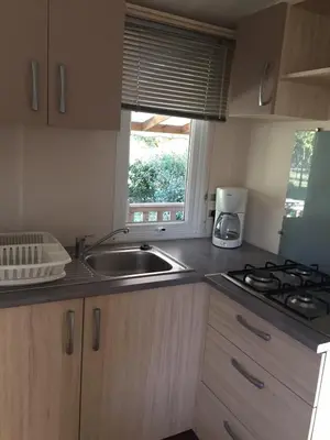 a kitchen with a sink and a stove and a window at Camping Via Romana in Prunelli-di-Fiumorbo