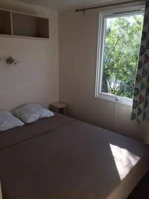 a bedroom with a bed and a window at Camping Via Romana in Prunelli-di-Fiumorbo