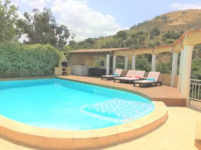 a large swimming pool with a deck and a patio at Villa SERENA in Sarrola-Carcopino