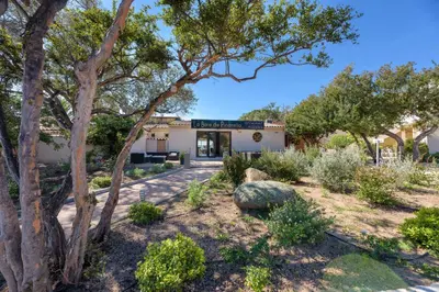 a view of the front of a building with trees at Hotel U Paesolu in Sainte-Lucie de Porto-Vecchio