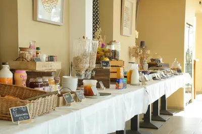 a row of white tables with food on them at Hotel U Paesolu in Sainte-Lucie de Porto-Vecchio