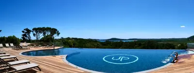 a swimming pool with lounge chairs next to a resort at Hotel U Paesolu in Sainte-Lucie de Porto-Vecchio