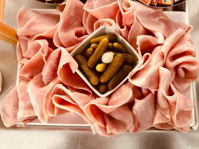 a tray filled with meat and pickles on a table at Kallisté in Ajaccio