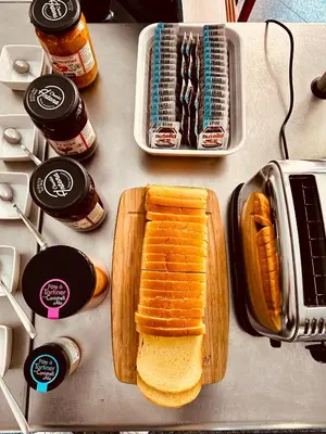 a table with a cutting board with bread and peanut butter at Kallisté in Ajaccio