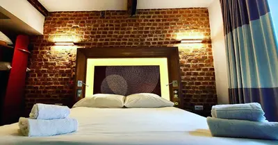 a bedroom with a large bed with a brick wall at Kallisté in Ajaccio