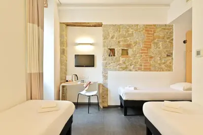 a hotel room with two beds and a chair at Kallisté in Ajaccio