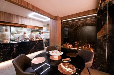 a man and woman sitting at a table with a plate of food at Hôtel Marinca & Spa in Olmeto