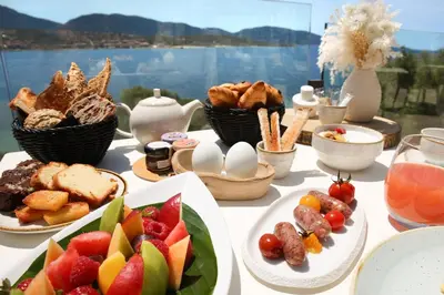 a deck with chairs and a view of the water at Hôtel Marinca & Spa in Olmeto