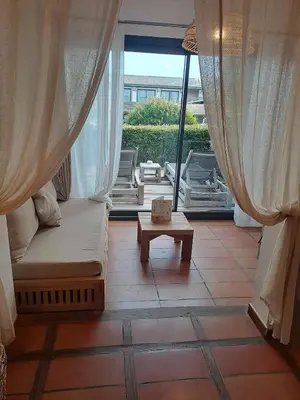 a room with a couch and a table and a window at Hôtel Le Roi Théodore & Spa in Porto-Vecchio