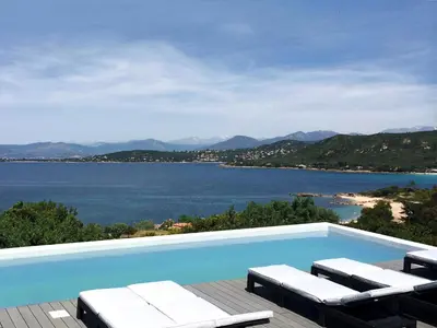 a swimming pool with chairs and a view of the water at Dililodge in Verghia