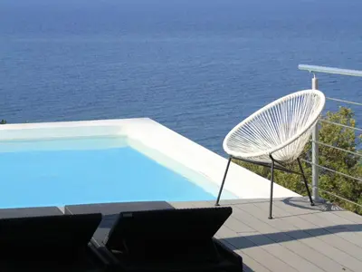 a white chair sitting next to a swimming pool at Dililodge in Verghia