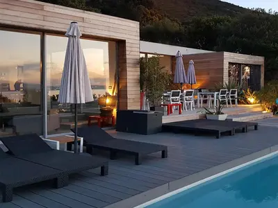 a pool with chairs and umbrellas on a deck at Dililodge in Verghia
